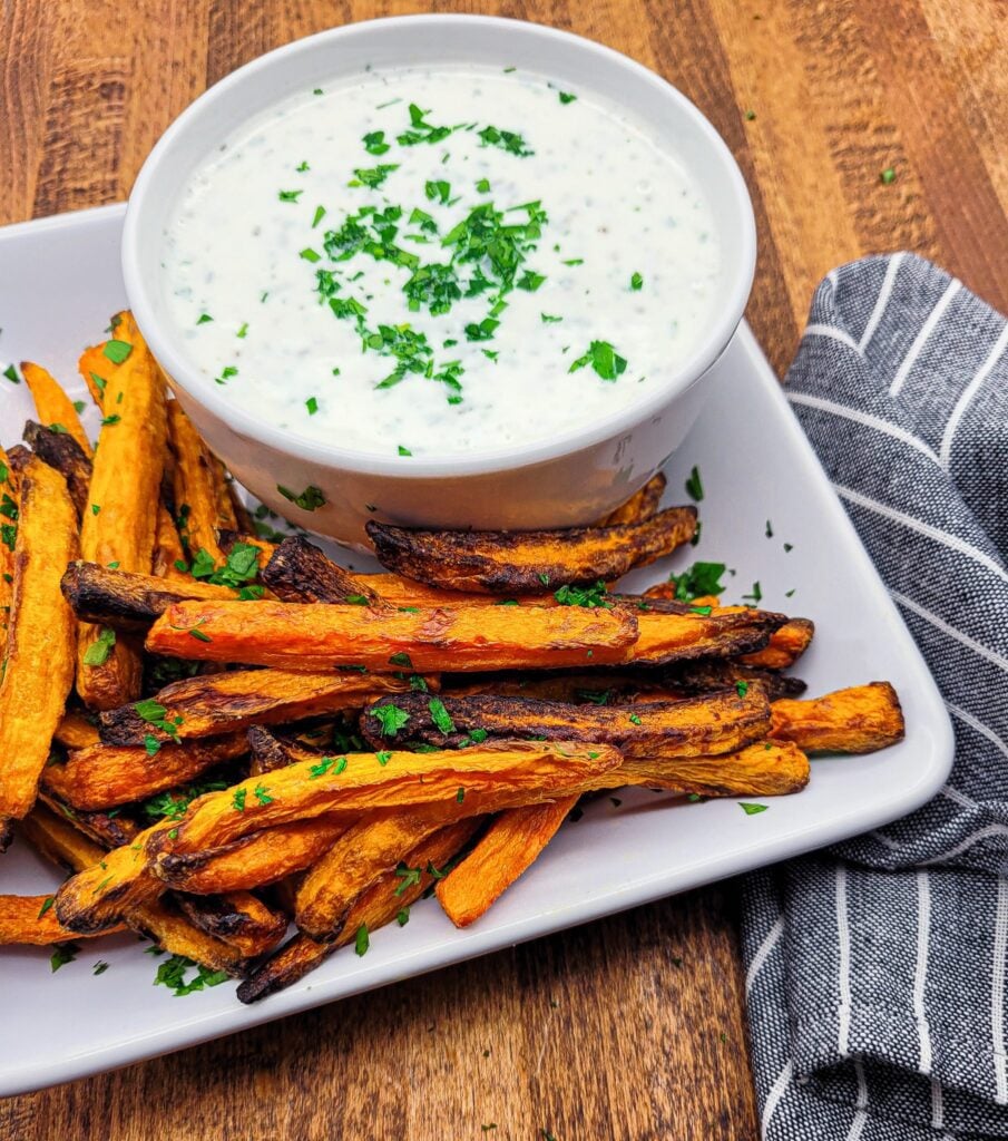 A plate of air fryer carrots with an herbed Greek yogurt dipping sauce.