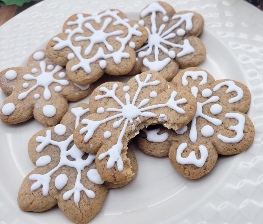 A close up of a plate of gingerbread cookies - one with a bite out!