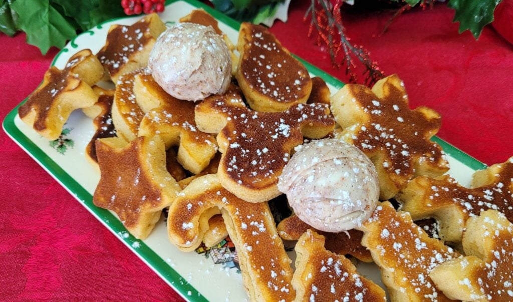 A platter of eggnog pancakes in festive Christmas shapes.