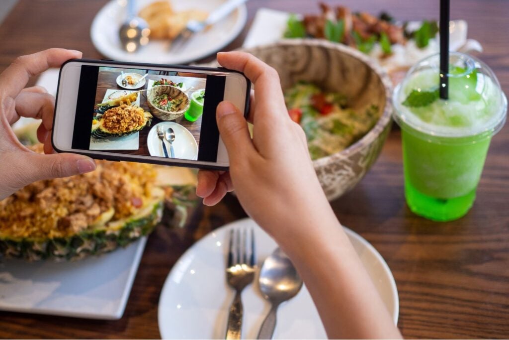 Someone taking a photo of a large spread of food