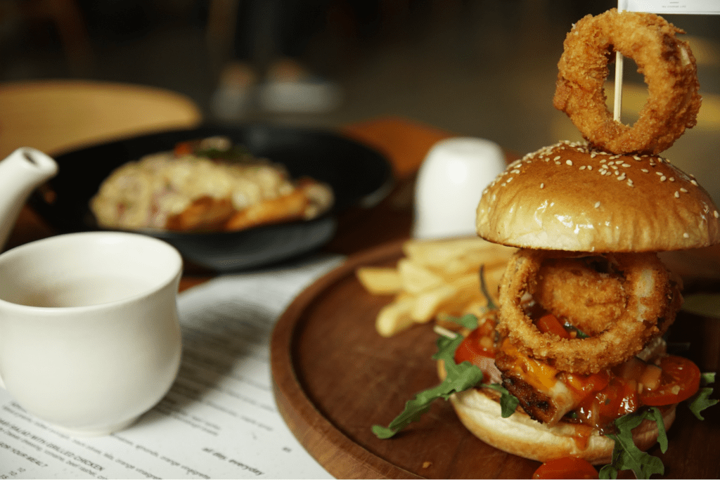 A gourmet hamburger with an onion ring on top