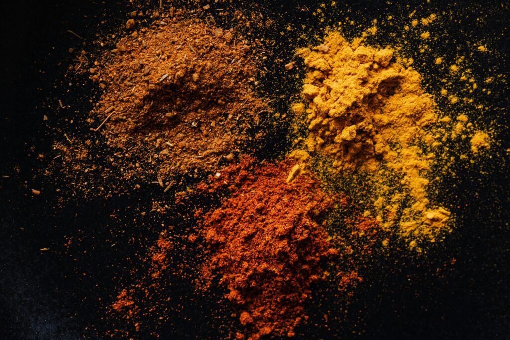 Assorted colorful dry powdered spices on a black background